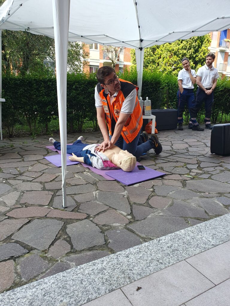 Un cittadino assistito da un formatore prova a eseguire le compressioni toraciche sul manichino da addestramento durante l'evento CentoPassiPerLaVita.