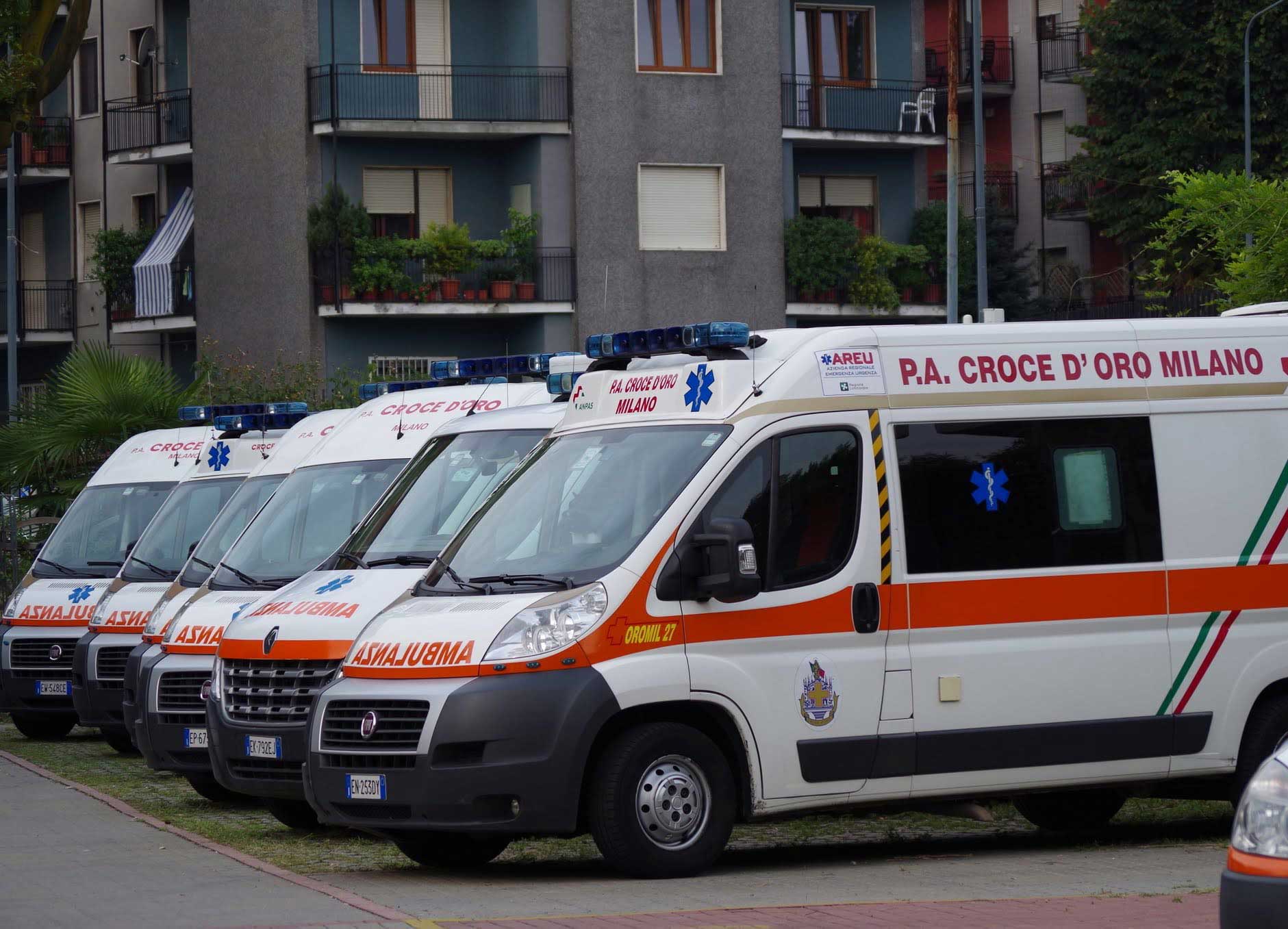 Tre ambulanze di soccorso avanzato della Croce d'Oro Milano parcheggiate in fila pronte per il servizio di emergenza.