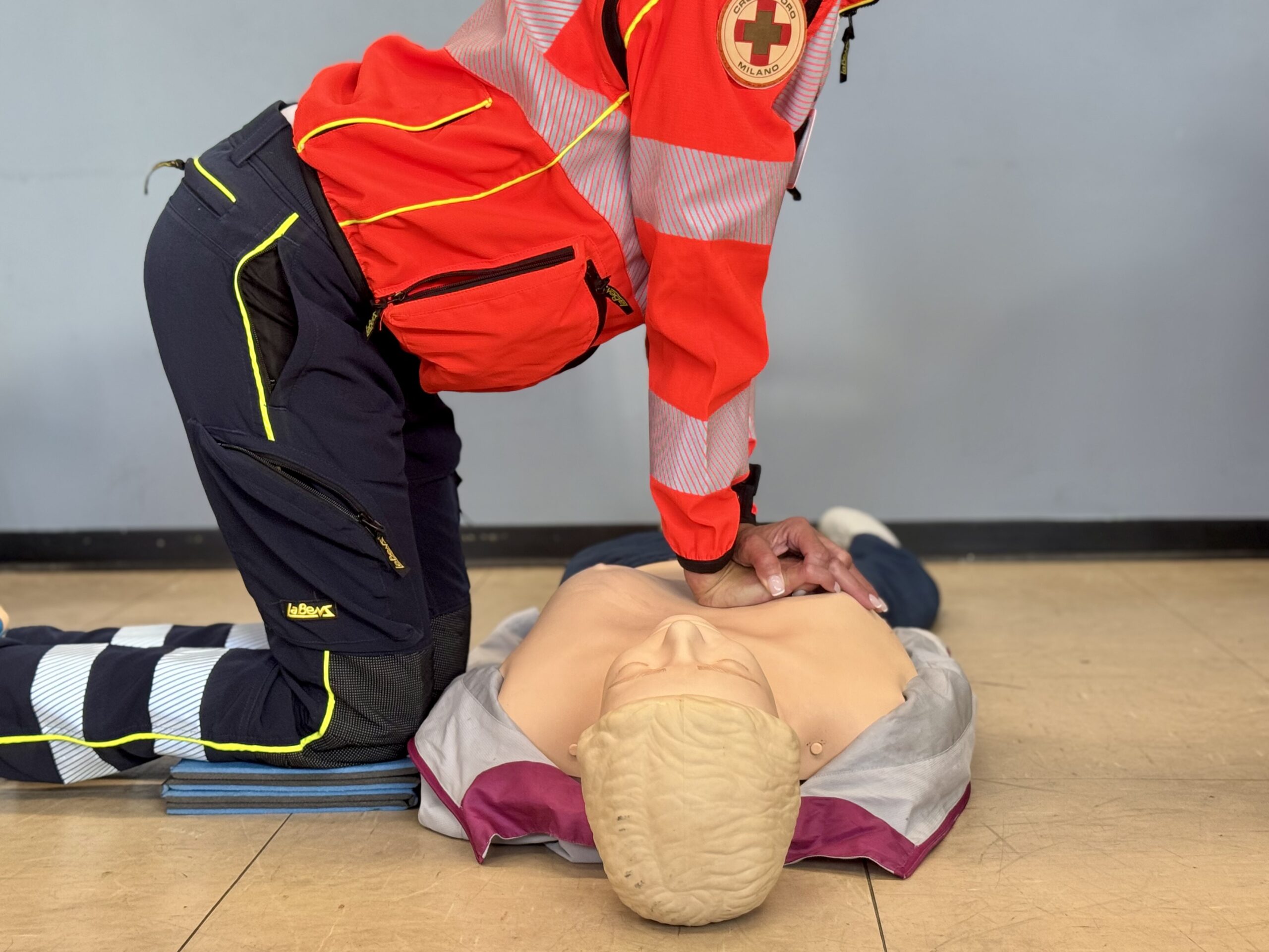 Volontario della Croce d'Oro Milano esegue le manovre di rianimazione cardiopolmonare (RCP) su un manichino da addestramento per adulti durante un corso.